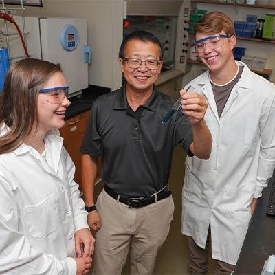 a teacher with students in lab coats